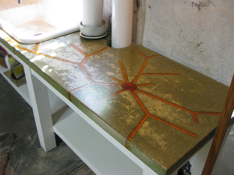 Green dyed concrete countertop with colored resin inlays.