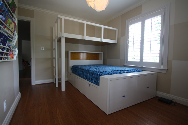 Bunk bed has a double mattress below with a transverse-mounted single above. Base has drawers and cabinets. Ladder and railings are solid ash.