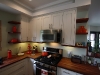 Kitchen cabinets with solid cherry butcher block countertops and floating shelves.